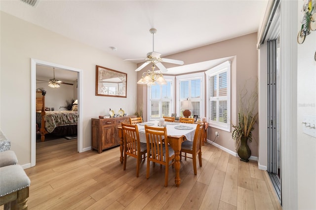 dining area featuring light wood-style floors, visible vents, baseboards, and a ceiling fan