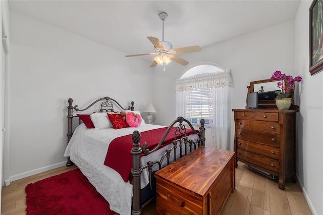 bedroom with light wood-type flooring, ceiling fan, and baseboards