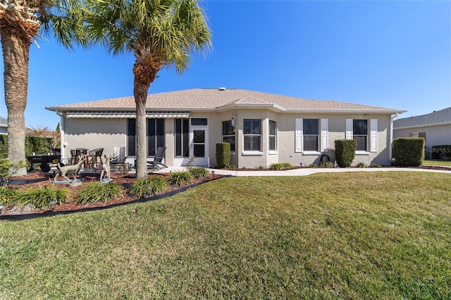 view of front of home with a patio, a front lawn, and stucco siding