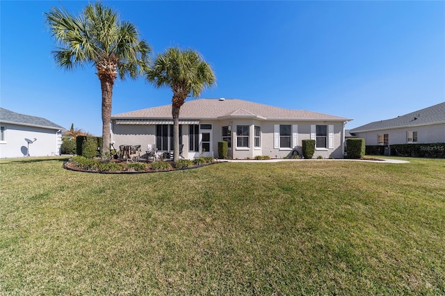 back of house with a lawn, an attached garage, and a patio