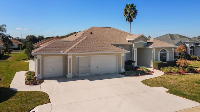 view of front of property featuring concrete driveway, an attached garage, a front lawn, and stucco siding