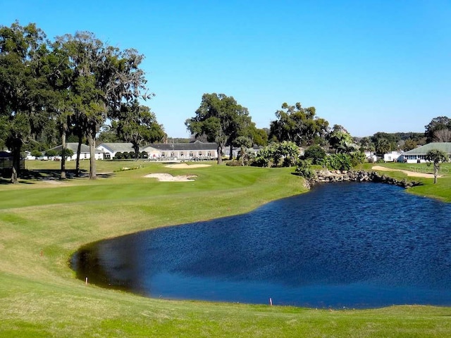 view of home's community with a lawn and a water view