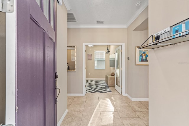 corridor with visible vents, crown molding, a textured ceiling, and light tile patterned flooring