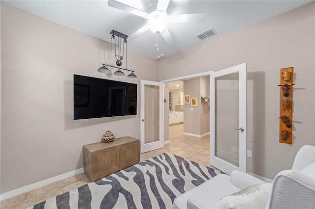 bedroom with a textured ceiling, ceiling fan, visible vents, baseboards, and french doors