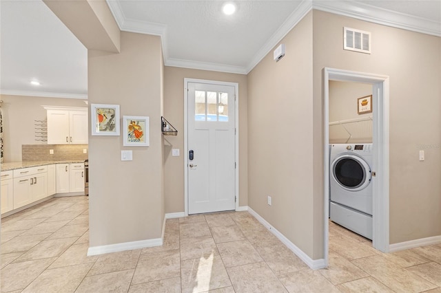 foyer with washer / dryer, visible vents, crown molding, and baseboards