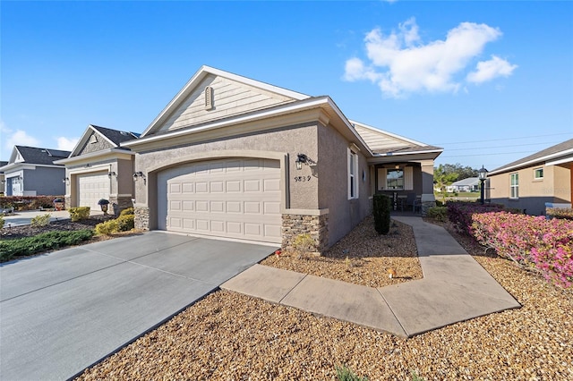 ranch-style home featuring an attached garage, concrete driveway, stone siding, and stucco siding