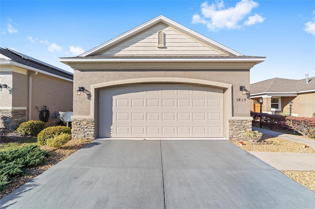 view of front of property featuring driveway, stone siding, a garage, and stucco siding