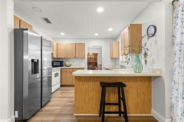 kitchen featuring black microwave, a peninsula, visible vents, stainless steel fridge with ice dispenser, and white electric range oven