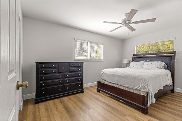 bedroom with ceiling fan, baseboards, and wood finished floors