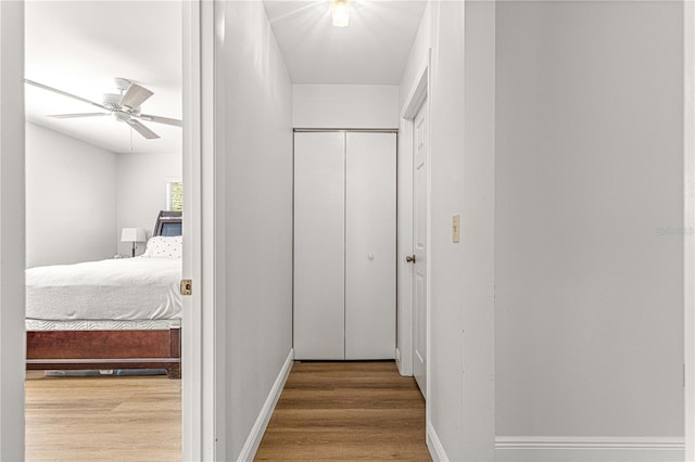 hallway featuring baseboards and wood finished floors