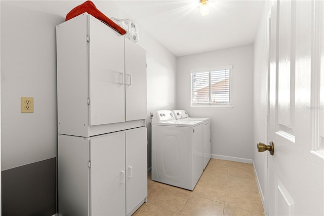 clothes washing area featuring laundry area, baseboards, washer and dryer, and light tile patterned flooring