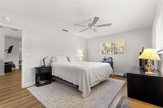 bedroom with light wood-type flooring, visible vents, and baseboards