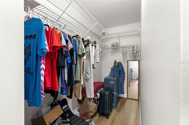 walk in closet with wood finished floors