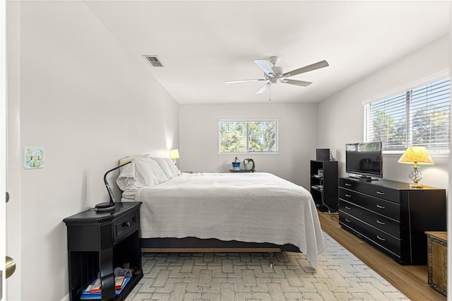 bedroom featuring a ceiling fan, light wood-type flooring, and visible vents