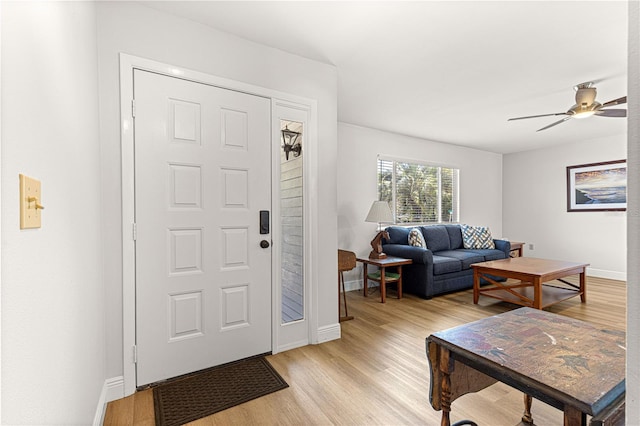 entrance foyer with light wood-style floors, ceiling fan, and baseboards