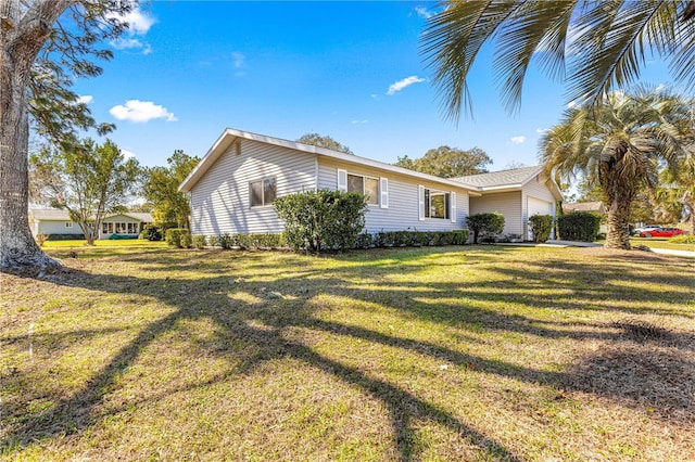 view of home's exterior with a garage and a lawn