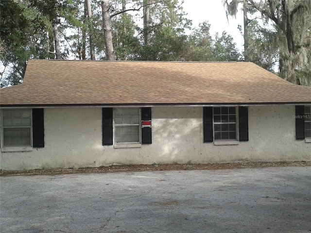 view of property exterior featuring a shingled roof