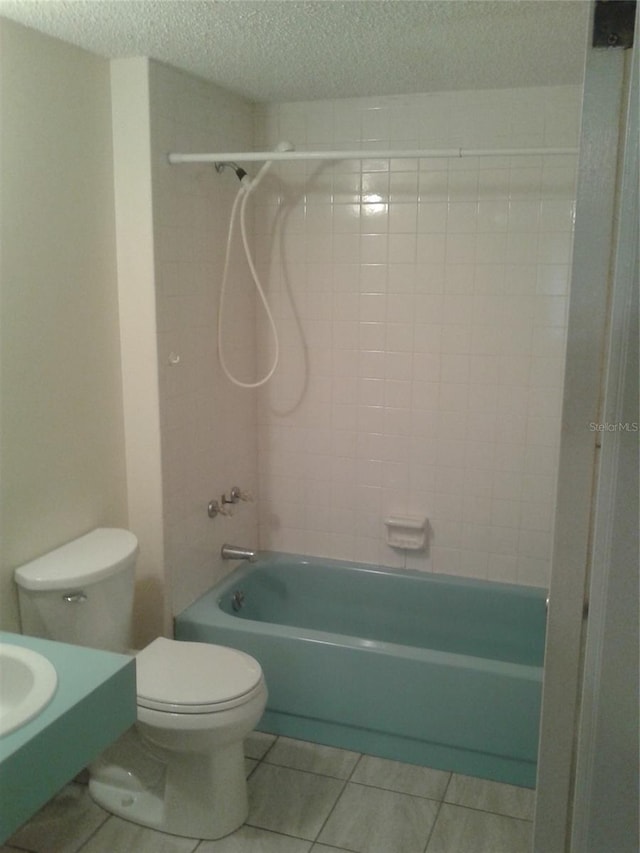 bathroom with toilet, tile patterned floors, a textured ceiling, and shower / bathing tub combination