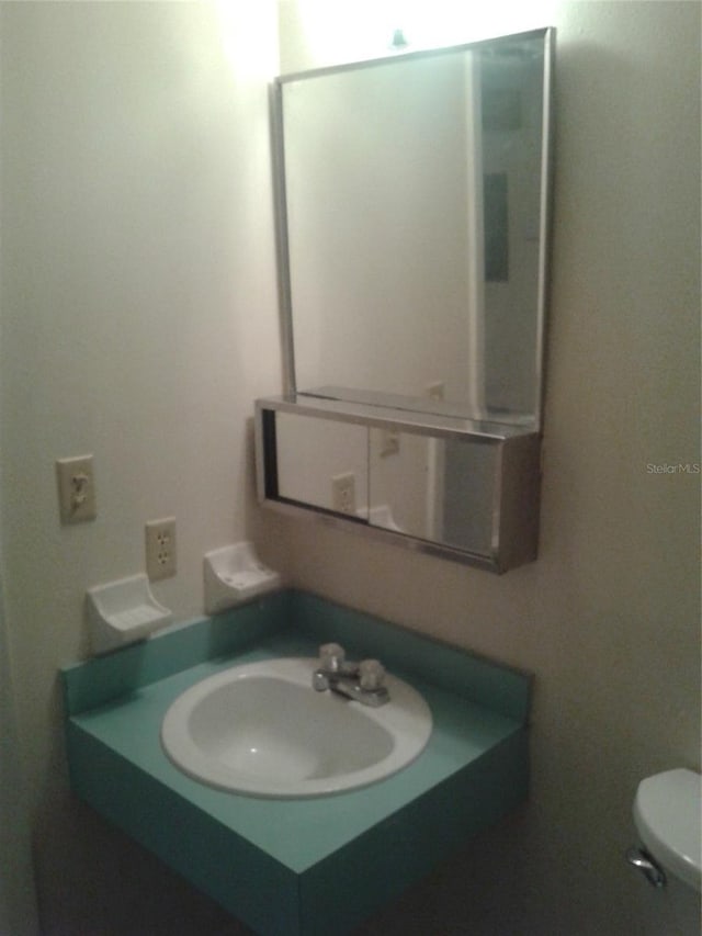 half bathroom with vanity and toilet