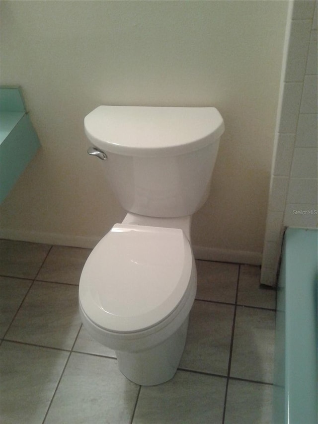 bathroom featuring tile patterned flooring, baseboards, and toilet