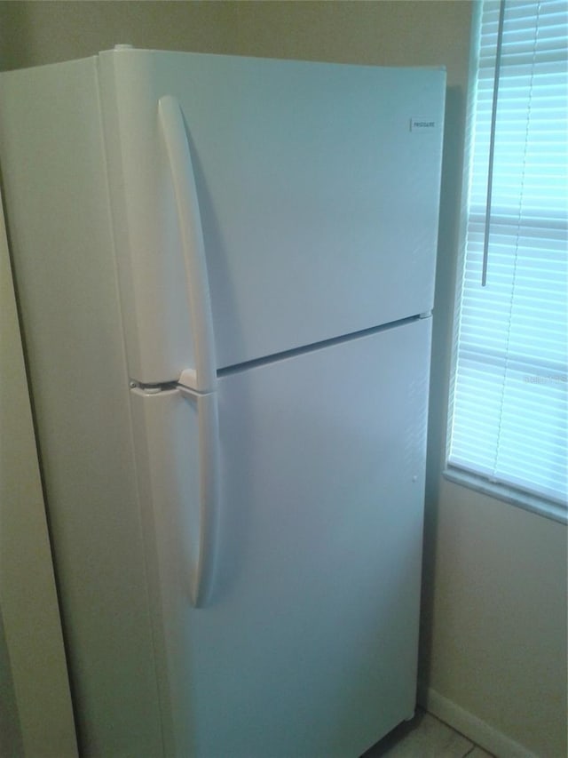 room details featuring freestanding refrigerator and baseboards