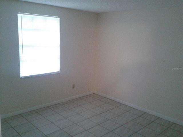 unfurnished room featuring plenty of natural light and baseboards