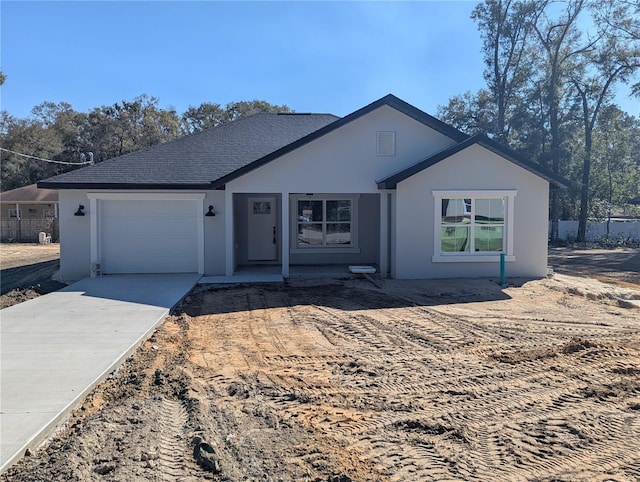 ranch-style home featuring a garage, concrete driveway, fence, and stucco siding