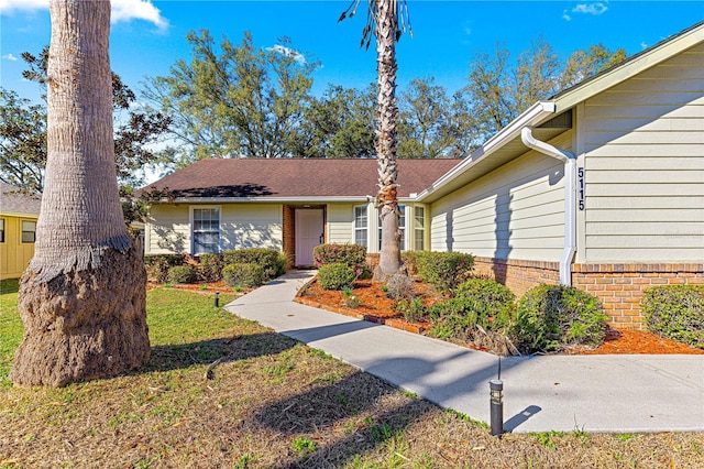 view of front of property with a front yard and brick siding