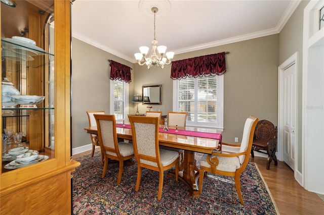 dining space with a chandelier, ornamental molding, wood finished floors, and baseboards