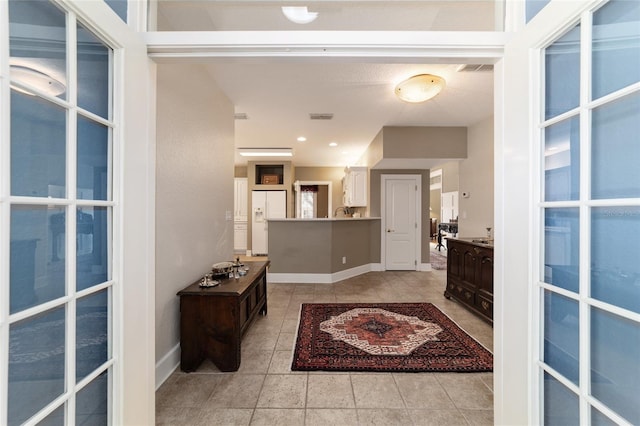 entryway featuring recessed lighting, light tile patterned flooring, visible vents, and baseboards