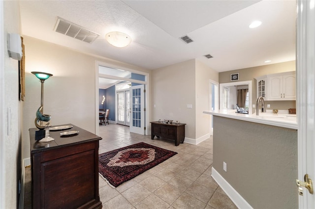 interior space with baseboards, visible vents, and french doors