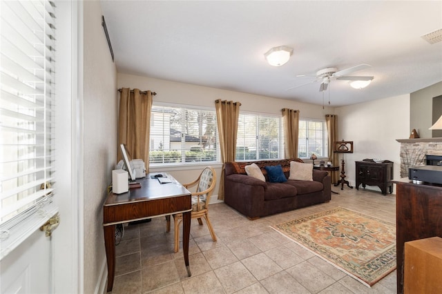 living room with light tile patterned floors, a fireplace, visible vents, and a ceiling fan