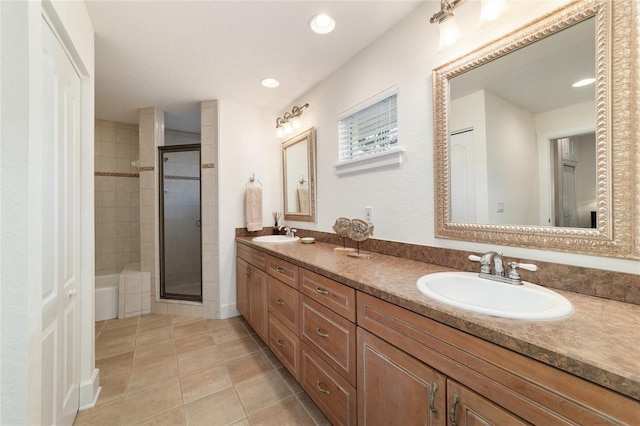 full bath featuring double vanity, tile patterned floors, a sink, and a shower stall