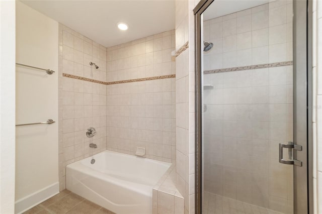 bathroom with tile patterned flooring, tiled shower / bath combo, and baseboards