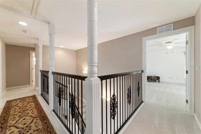 hall with baseboards, attic access, visible vents, and carpet flooring