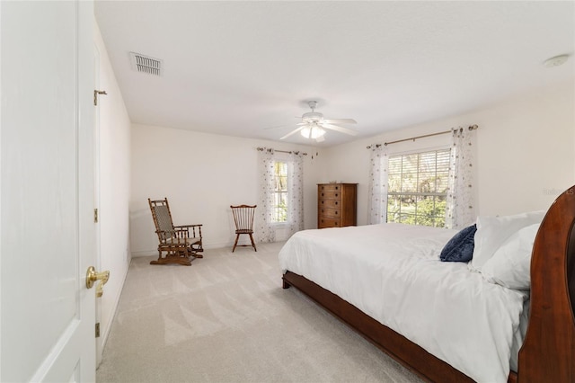 carpeted bedroom with a ceiling fan, visible vents, and baseboards