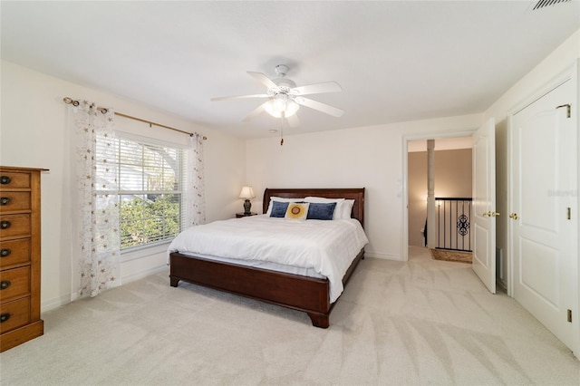 bedroom featuring ceiling fan, baseboards, and light colored carpet