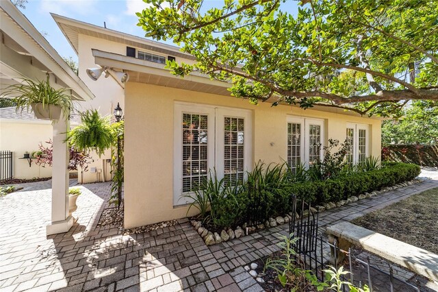 view of side of home with fence, a patio, and stucco siding