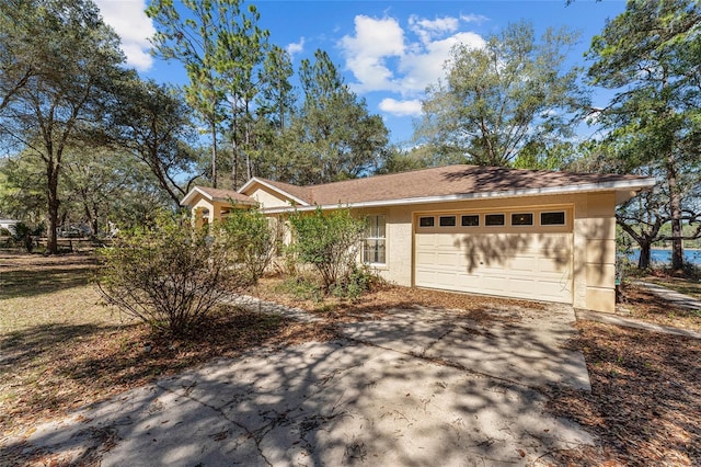 view of front facade with a garage, driveway, and stucco siding