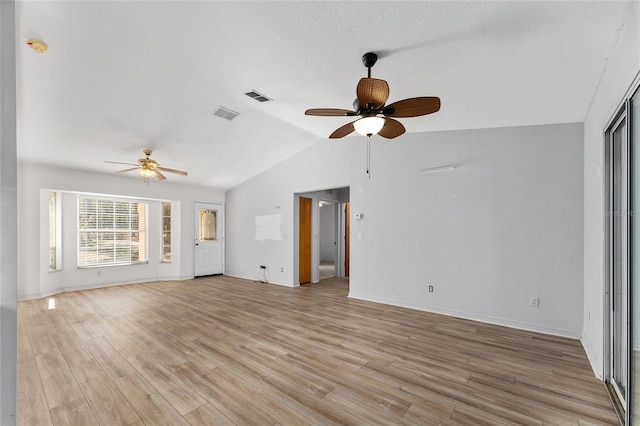 unfurnished living room with light wood-type flooring, visible vents, and lofted ceiling