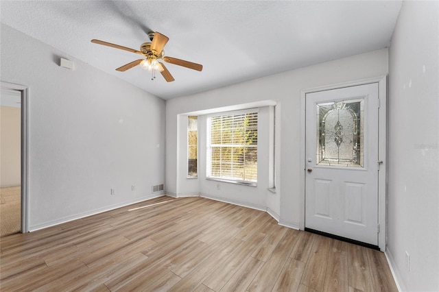 foyer with baseboards, light wood-style flooring, visible vents, and a ceiling fan