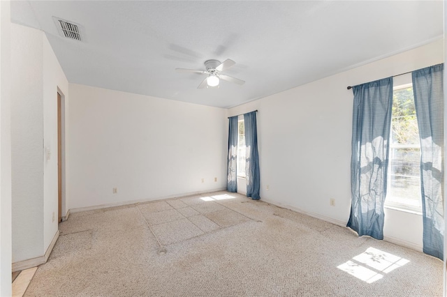 unfurnished room with baseboards, visible vents, and a ceiling fan