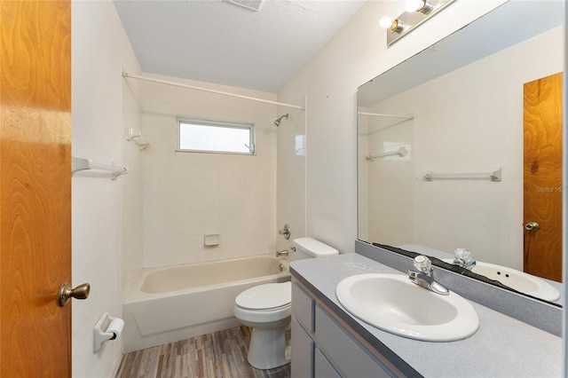 bathroom with shower / bath combination, toilet, wood finished floors, a textured ceiling, and vanity