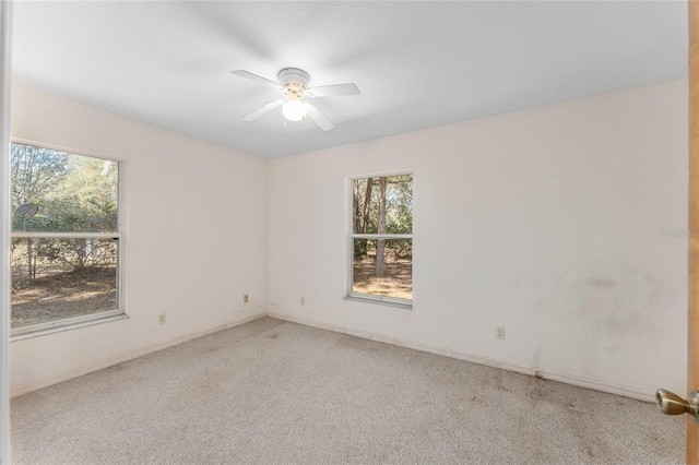 unfurnished room with light colored carpet, ceiling fan, and baseboards