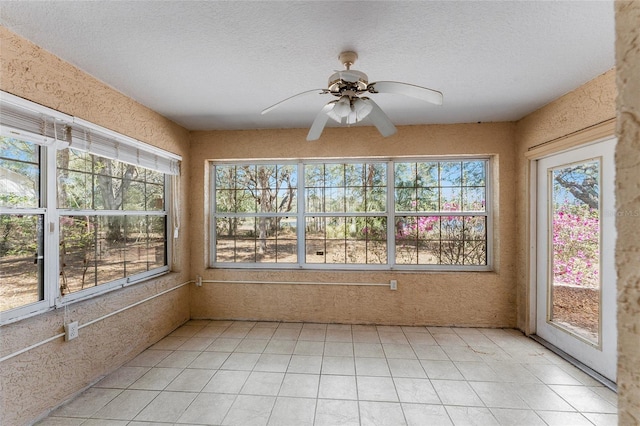 unfurnished sunroom featuring ceiling fan