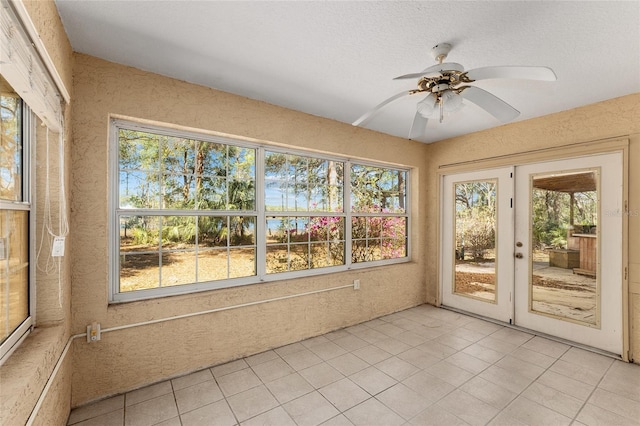 unfurnished sunroom with ceiling fan