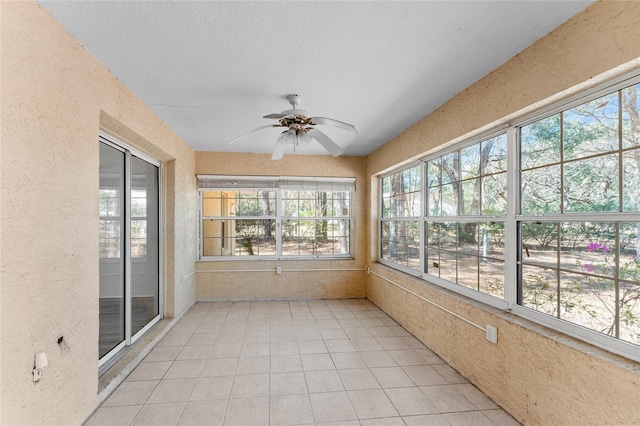 unfurnished sunroom featuring ceiling fan