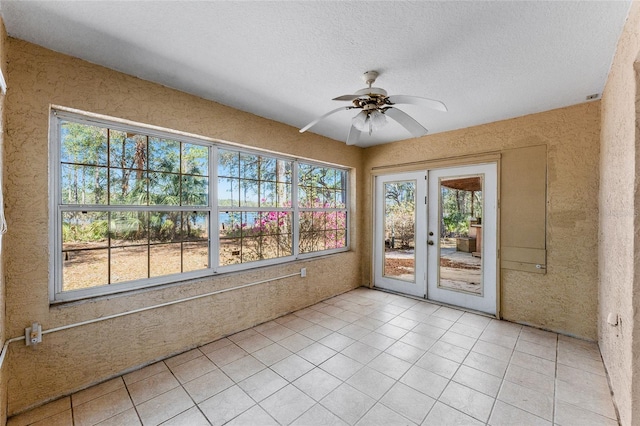 unfurnished sunroom with ceiling fan