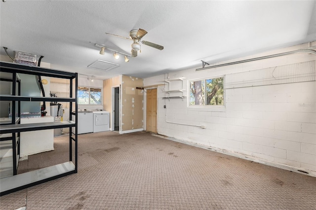 garage with washer and dryer, ceiling fan, and concrete block wall