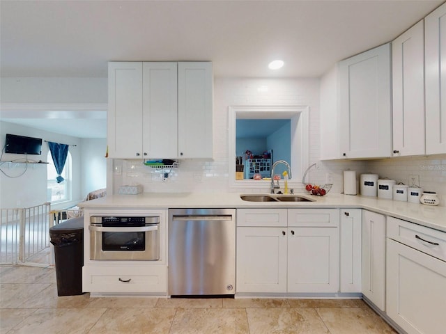 kitchen featuring a sink, white cabinetry, stainless steel appliances, and light countertops